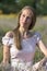 Beautiful woman in sunny day wearing pink dress and sitting in fresh lavander field, enjoying beauty of nature