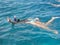 Beautiful woman swims in the Red Sea and engaged in snorkelling with a snorkel and mask. And she shows the Victory sign