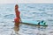 Beautiful woman in swimsuit posing in sea. Idea of adventure time, surf sport, holiday trip and summer time, copy space