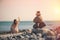 Beautiful woman in a swimsuit walking along the beach against the background of a pyramid of stones. Blurred female with stones on