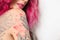 Beautiful woman with tattoos on body against background, closeup