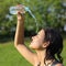 Beautiful woman throwing herself water from a plastic bottle