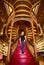 Beautiful woman tourist stands on large wooden staircase with red steps inside library bookstore  Livraria Lello in historic