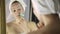 Beautiful woman in towel doing cosmetic procedures in home. face massage with massager