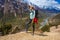 Beautiful Woman Traveler Backpacker Mountains Path.Young Girl Looking Top Hill and Take Rest.North Summer Snow Landscape