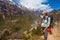 Beautiful Woman Traveler Backpacker Mountains Path.Young Girl Looks Horizon Take Rest.North Summer Landscape Background