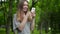 Beautiful woman uses cell smartphone outdoors in the park - detail