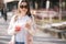 Beautiful woman using phone and drinks lemonade outdoor. Young blogger spend time in park