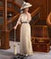 Beautiful woman in a victorian dress standing in front of her luggage