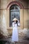 A beautiful woman in Vietnam`s national costume is standing and catching a sun hat. While taking pictures