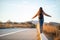 Beautiful woman walking and balancing on street curb or curbstone during sunset