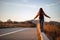 Beautiful woman walking and balancing on street curb or curbstone during sunset