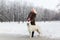 Beautiful woman walking with White Swiss shepherd dog in winter