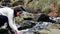 Beautiful woman washing face with clean water mountain river