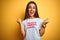 Beautiful woman wearing fanny t-shirt with irony comments over isolated yellow background celebrating surprised and amazed for
