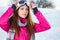 Beautiful woman wearing goggles in snowy winter