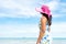 Beautiful woman wearing hat beach and sunglasses stand on hands over sandy beach