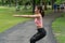 Beautiful woman wearing orange sports warm up before exercise. Sporty young woman warming up before running in the public