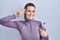 Beautiful woman wearing sportswear holding water bottle smiling pointing to head with one finger, great idea or thought, good