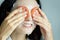 A beautiful woman wearing a towel and a white bathrobe has mask on face-covering eyes with sliced tomatoes with happy and relaxing