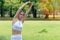 Beautiful woman wearing white sports warm up before exercise. Sporty female warming up before running in the public park on