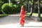 A beautiful woman wears a traditional Moroccan dress in red and embroidered in gold and silver. The girl poses for wedding photos