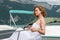 Beautiful woman in white dress sitting on a boat and looks away.