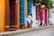 Beautiful woman on white dress walking alone at the colorful streets of the colonial walled city of Cartagena de Indias