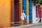 Beautiful woman on white dress walking alone at the colorful streets of the colonial walled city of Cartagena de Indias