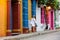 Beautiful woman on white dress walking alone at the colorful streets of the colonial walled city of Cartagena de Indias