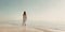 Beautiful woman in a white dress walking on the beach