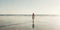 Beautiful woman in a white dress walking on the beach