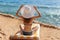 beautiful woman in white hat and bikini sitting on lounger near sea on beach in Egypt. Summer holiday concept travel