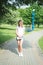 Beautiful woman in white t-shirt and denim shorts walks along the footpath in the city