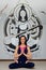 Beautiful woman yoga trainer sitting in lotus position on the background of the picture of the Indian goddess. Healthy lifestyle,