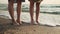 Beautiful women barefoot walking on beach at sunrise. Girls enjoy a walk on the beach at sunset