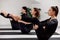 Beautiful women doing pilates in a bright studio. Three sportswomen in black sportswear do static exercises while