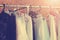 Beautiful women`s clothes hang on the hanger in the closet. Toning in the style of instagram. Close-up, soft focus