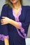 Beautiful women\'s home clothes.. A girl is standing in a beautiful dark purple negligee, dressing gown, negligee