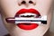 Beautiful women`s lips, bright stylish makeup. stick lipstick in the teeth, fashion concept