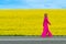 Beautiful women walking in amazing field of yellow rapeseed in the countryside. Canola oil plants