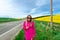 Beautiful women walking in amazing field of yellow rapeseed in the countryside. Canola oil plants