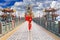 Beautiful women wearing dresses red cheongsam holding an umbrella walking on the bridge at Zuoying Yuandi temple,Taiwan