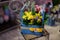 Beautiful wooden box of crimson, white and yellow flowers decorated with green leaves and red berries