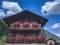 Beautiful wooden mountain house with decorative flowers on balconies