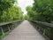 Beautiful wooden walkway across a river coming from a very safe bridge