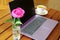 Beautiful workplace of a young woman. Violet computer, flowers and tea.