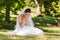 Beautiful worried bride sitting at park