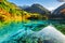 Beautiful yellow autumn forest reflected in the Five Flower Lake