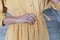 Beautiful yellow corduroy dress on a girl close-up. Hand on the belt